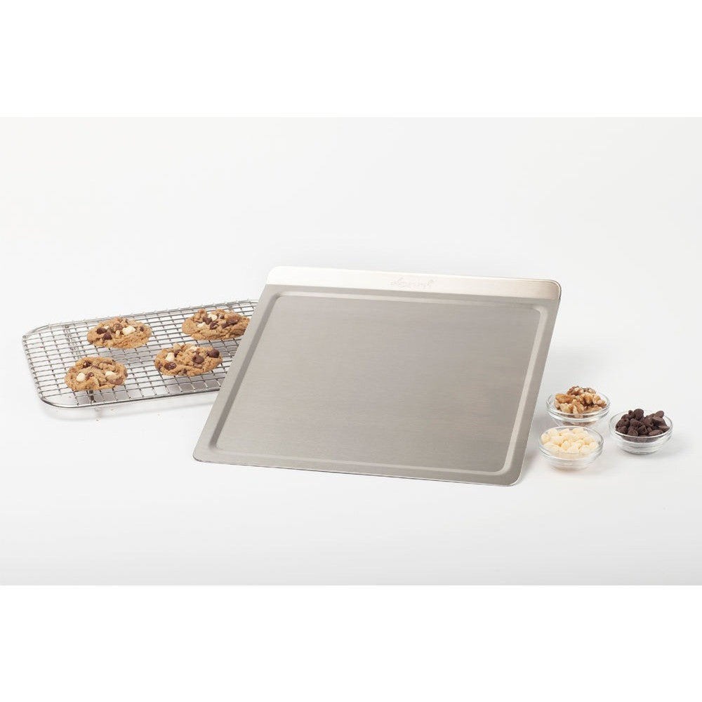 Stainless steel cookie sheet with cookies and toppings on a cooling rack and bowls.