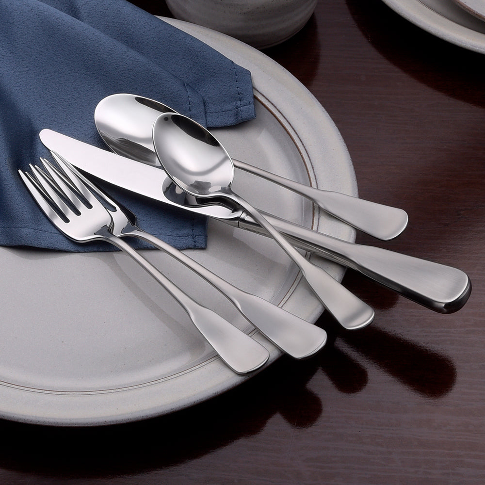 Candra 45 Piece Flatware Set displayed on a plate with a blue napkin