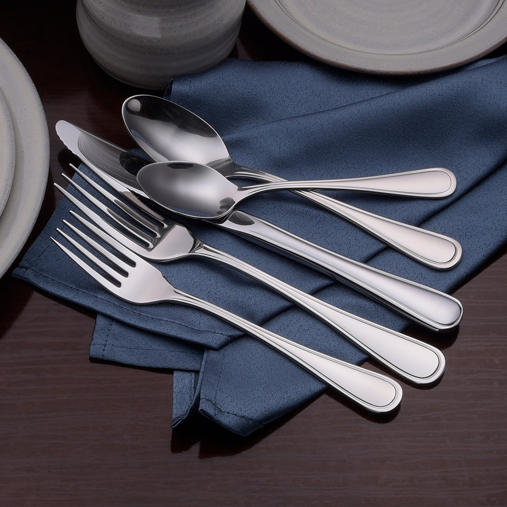 Classic Rim flatware set featuring polished teardrop handles and various utensils on a blue napkin.