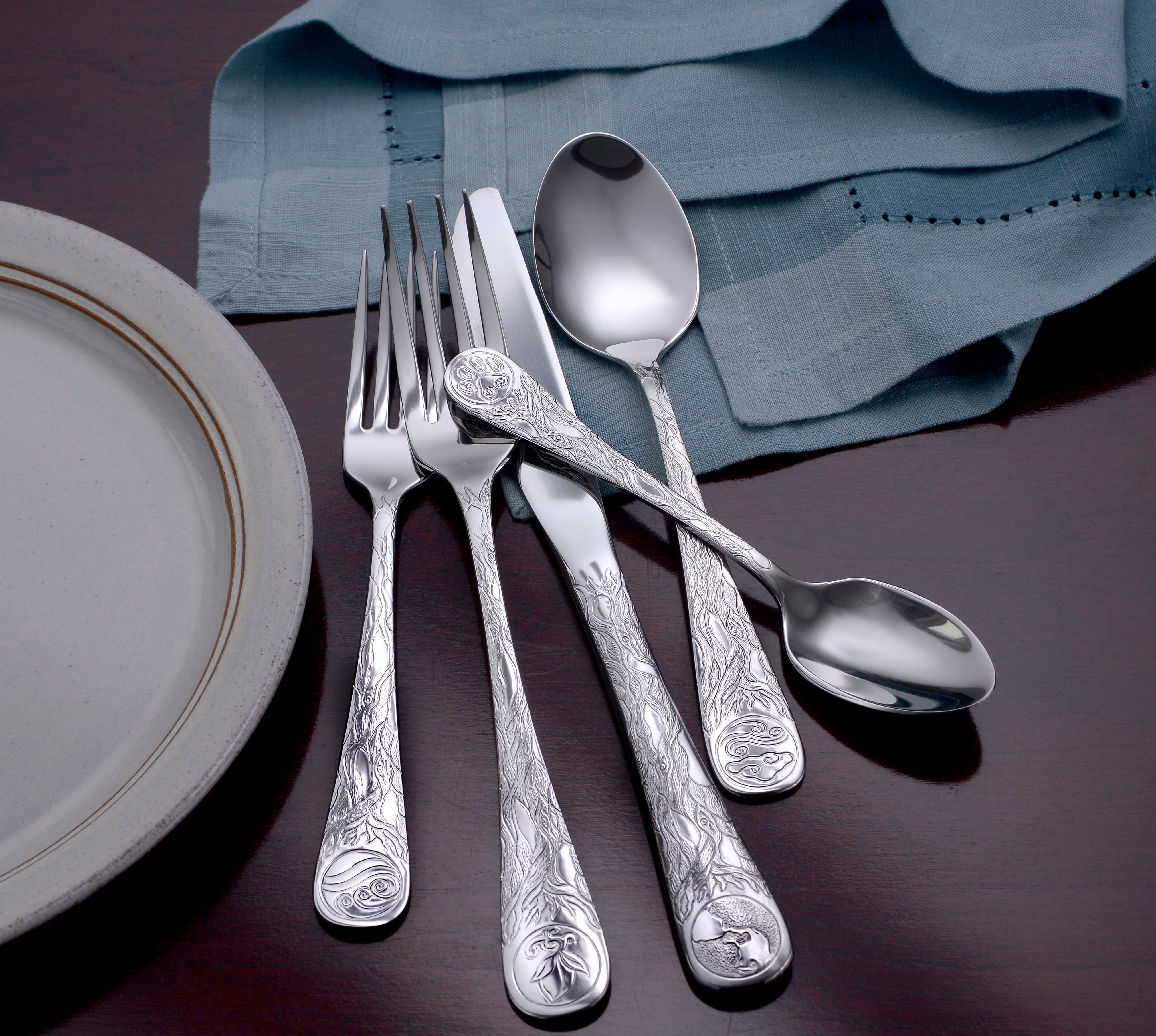 Earth Pattern Flatware set featuring intricate designs on handles, including a fork, knife, and spoon.