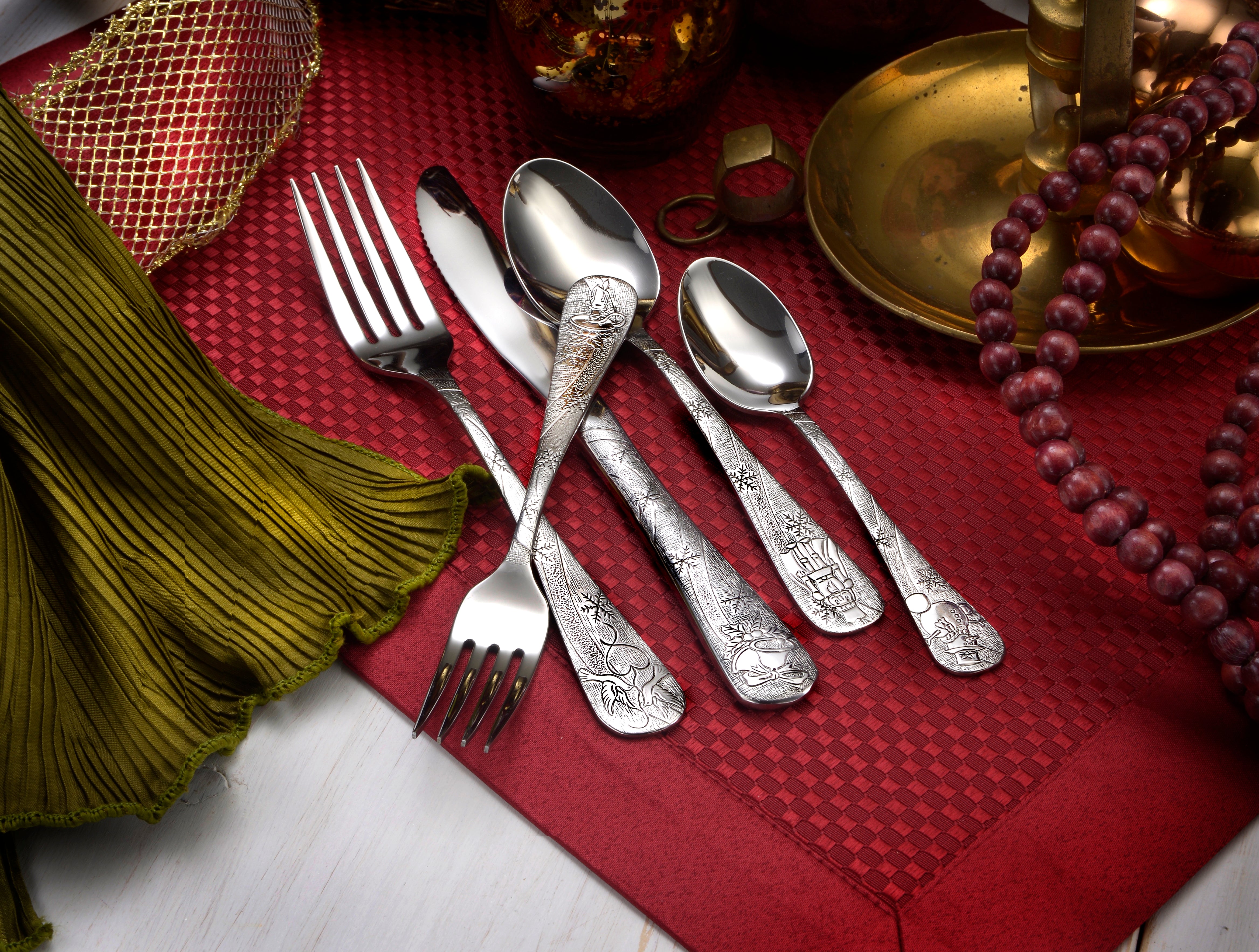 Holidays flatware set displayed on a festive table setting with decorative elements.