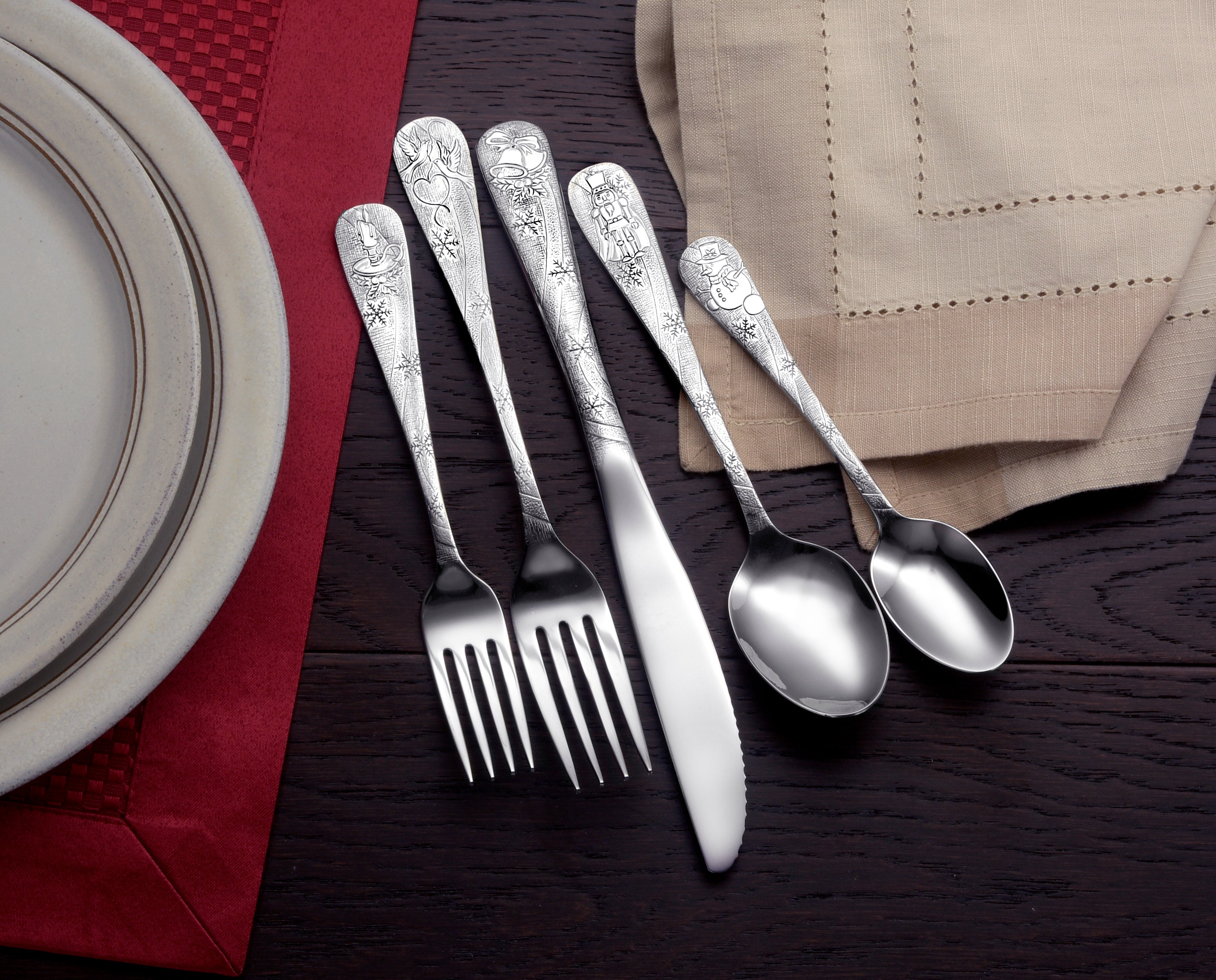 Five pieces of decorative flatware with seasonal designs on a table setting
