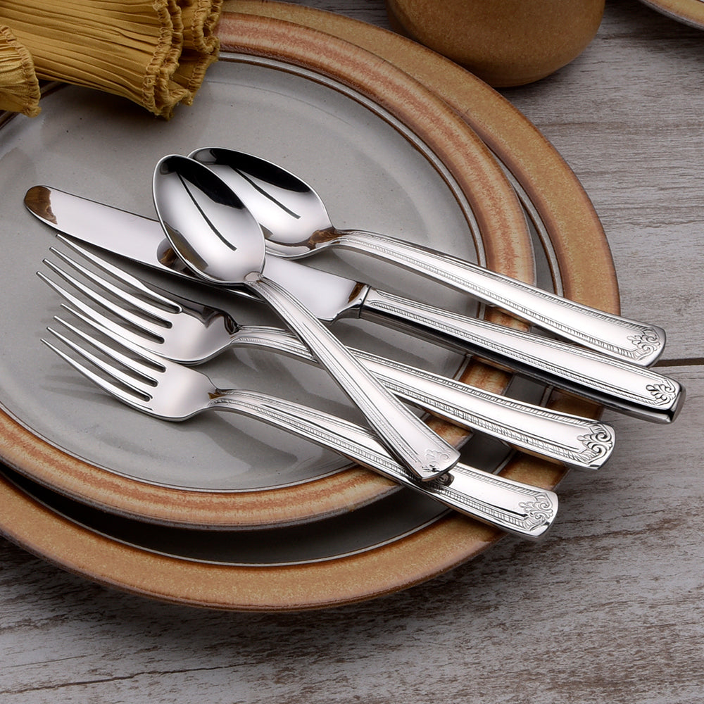 Five pieces of Prestige flatware on plates, including forks, spoons, and knives.