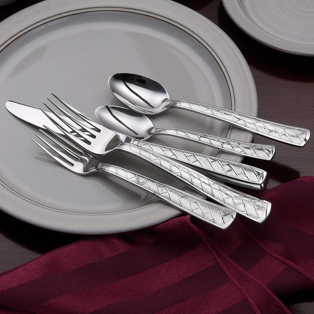 Weave flatware set featuring a basket design on a table setting with plates and a napkin