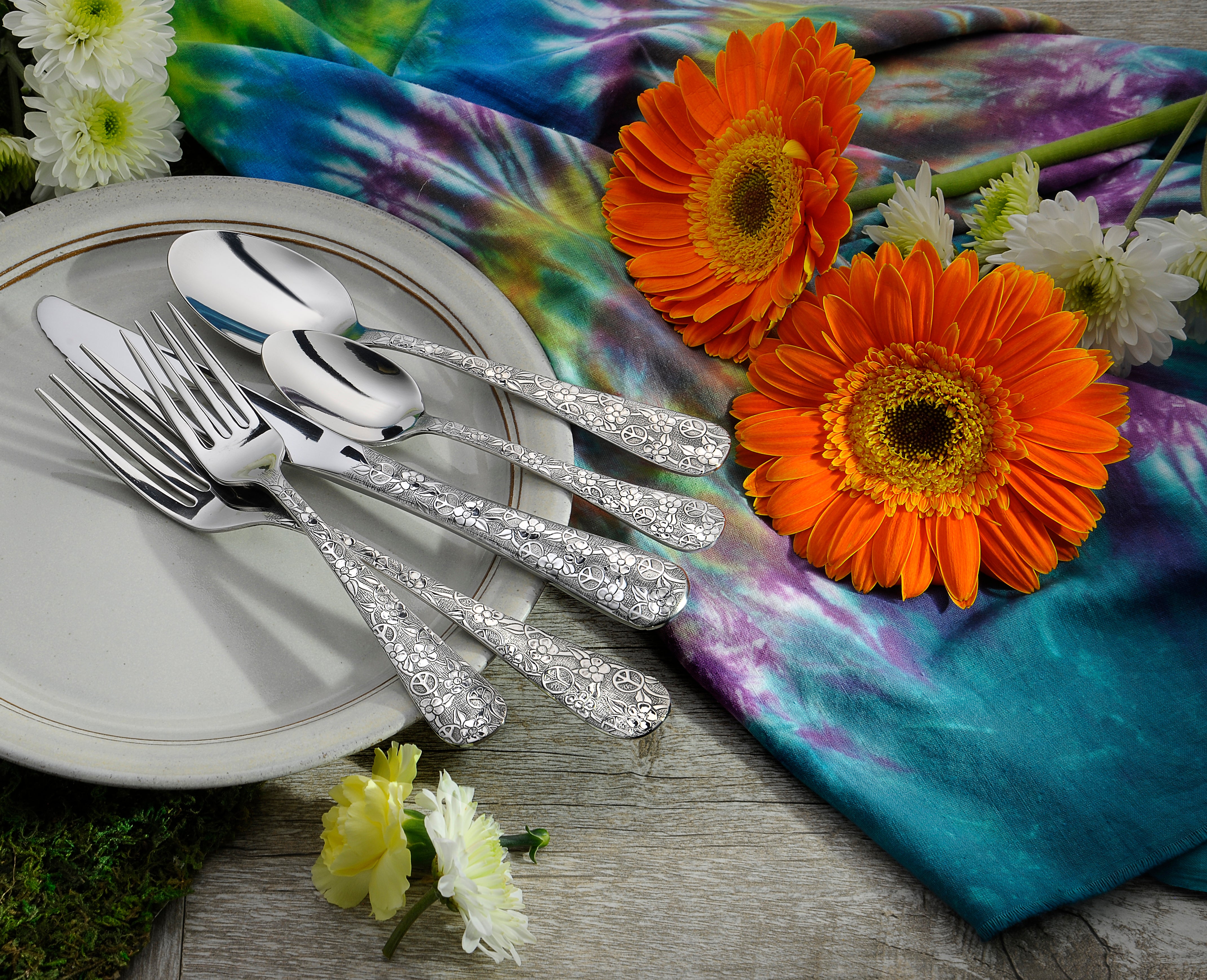 Woodstock 65 Piece Set displayed on a plate with colorful flowers and fabric