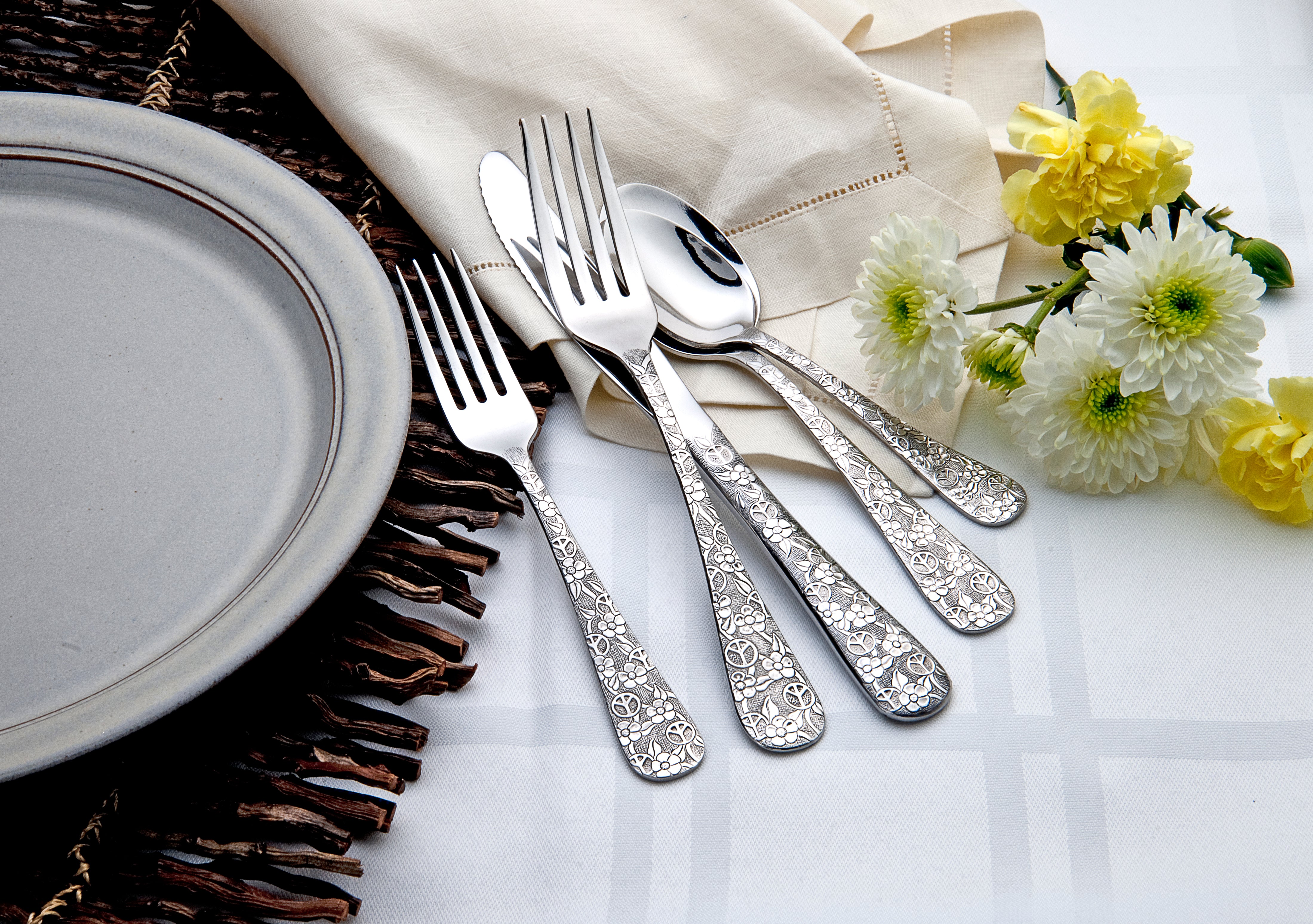 Five pieces of Woodstock flatware with floral design on a table setting